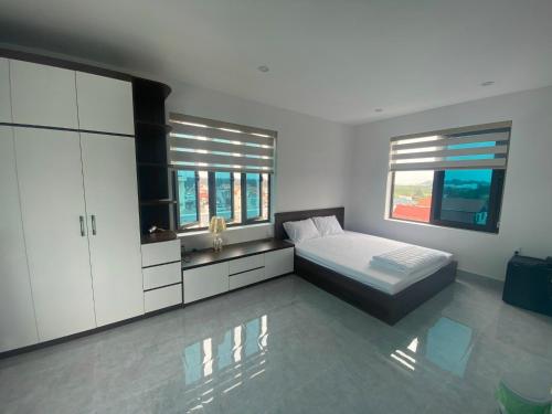 海防Hong Kong Hotel的一间卧室设有一张床和两个窗户。