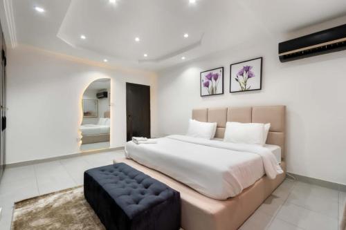 拉各斯Azure的一间大卧室,配有一张大床和一张凳子