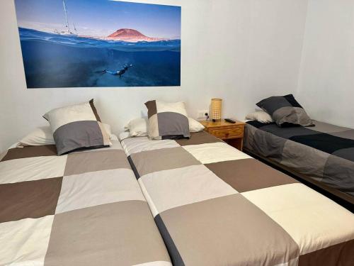塞博河畔卡莱塔La Graciosita Traditional Home的一间卧室设有两张床,墙上挂着一幅画
