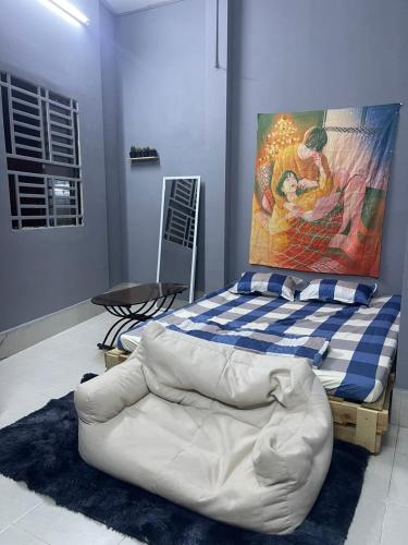 芹苴Nhà Nghỉ Thành Đạt的卧室配有一张白色床,墙上挂有绘画作品
