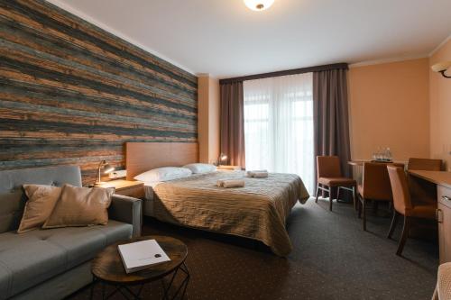 奥格罗杰涅茨Hotel Pod Figurą的酒店客房,配有床和沙发