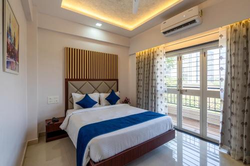 浦那StayBird - Divine Suites, Business Hotel, Kharadi的一间卧室设有一张床和一个大窗户