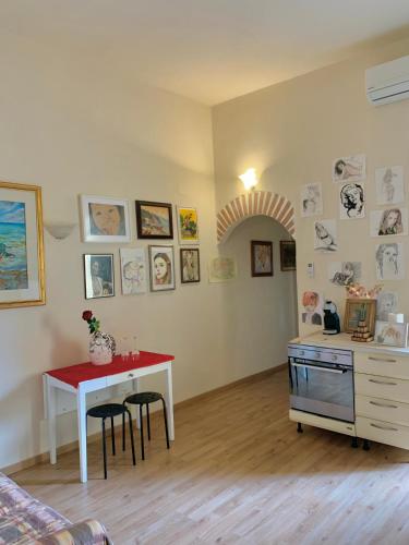 蒙特卡蒂尼泰尔梅Appartamento Meri, Montecatini Terme的厨房配有桌子和带凳子的台面