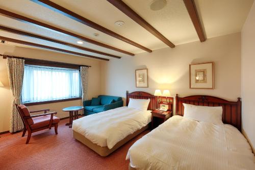 郡上市太阳成员西路嘉诺酒店的酒店客房,设有两张床和一张蓝色椅子