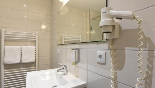 杜塞尔多夫HOTEL Am Spichernplatz的浴室配有盥洗盆和吹风机