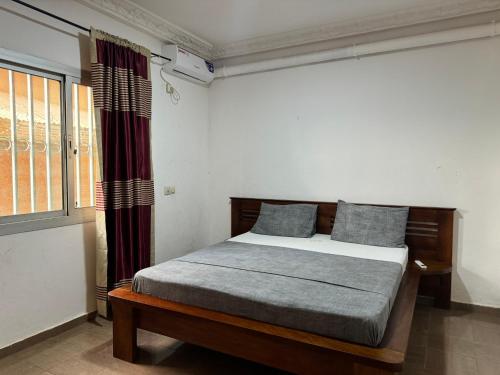 雅温得Appart meublé haut standing, WIFI, TV - Yaoundé, Omnisports的一间卧室设有一张床和一个窗口