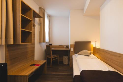 科隆Köln 2020的小房间设有一张床和一张书桌