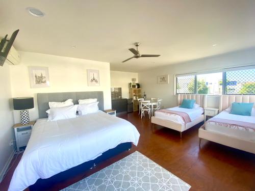 黄金海岸Self contained guest house - sleeps 4的一间卧室配有两张床、一张沙发和一张桌子