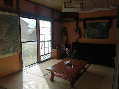 上川町Yukiumi House的客厅配有咖啡桌和吉他