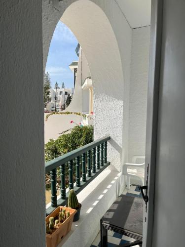 甘达坞伊港Bel appartement au coeur du Port El Kantaoui的通往阳台的拱形门廊,阳台种植了植物