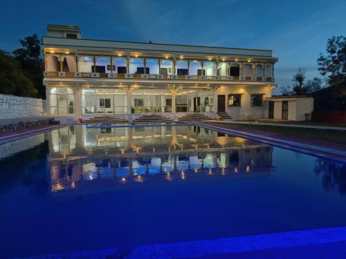 乌代浦Monkey Retreat Resort的一座在晚上设有游泳池的大房子
