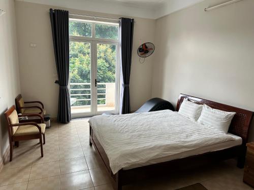 和平Thiên Bình Hotel的一间卧室设有一张床和一个大窗户