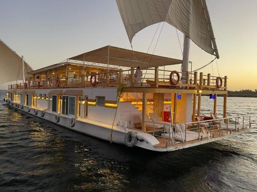 卢克索Dahabiya Nile Sailing-Every Monday 4 Nights from Luxor-Every Friday 3 Nights from Aswan的坐在水中的船