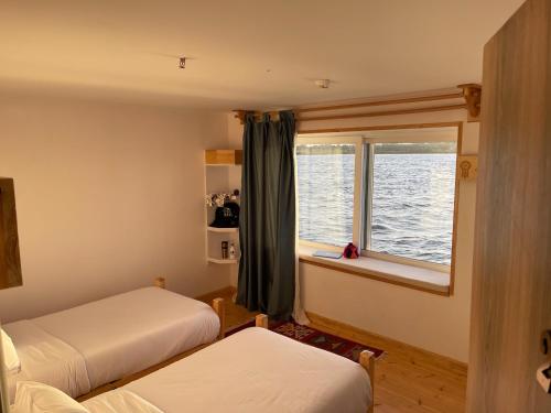 卢克索Dahabiya Nile Sailing - Mondays 4 Nights from Luxor - Fridays 3 Nights from Aswan的一间卧室设有两张床和窗户。