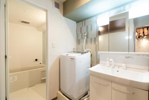 神户三宮5分、屋上バーベキュー可能！　キッチン付パーティ向コンド的一间带水槽、卫生间和镜子的浴室