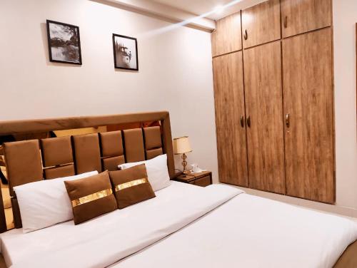 伊斯兰堡Morbex Guest House Islamabad的卧室配有白色大床和木制橱柜