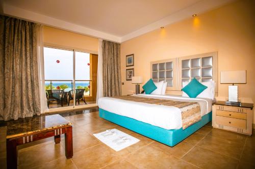 赫尔格达托皮特萨赫尔哈希什酒店的一间卧室设有一张大床,享有海景