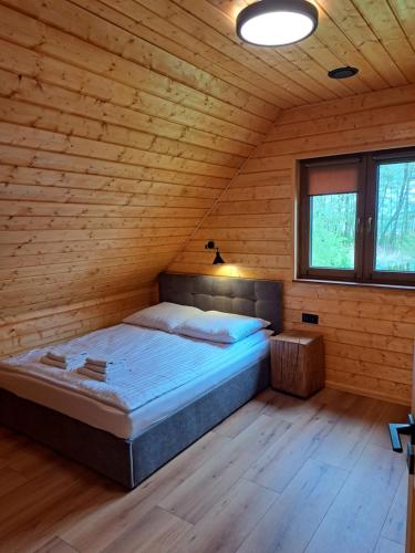 翁格罗维茨Kamienica House 9的木制客房内的一间卧室,配有一张床