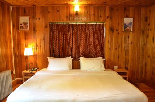帕罗Sinchula Villa的一间卧室设有一张大床和一个窗户。