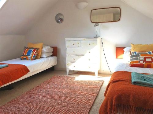 KentBarnacle Drift - a stylish Whitstable cottage的一间卧室配有两张单人床和一个梳妆台