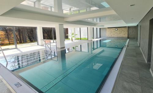 施卢赫湖Kurhotel Schluchsee - App 3413 - Jakob - mit Indoorpool, Schluchsee的一座位于大楼内的蓝色海水室内游泳池