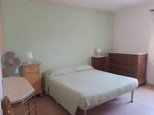 奎尔瑟Casa vacanze Sa Rocchitta的一间卧室配有两张床、一个梳妆台和椅子