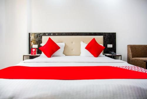 哈里瓦Hotel Raj Ganga Haridwar Near Raja Ji National park Jeep Safari - Excellent Customer Choice- Best Seller的一间卧室配有一张带红色枕头的大床