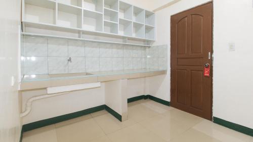 马尼拉RedDoorz @ Western Bicutan Transients Inn的厨房配有柜台、水槽和门