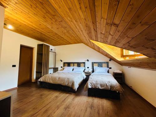 泰斯Bujtina Terthorja的卧室设有两张床铺和木制天花板