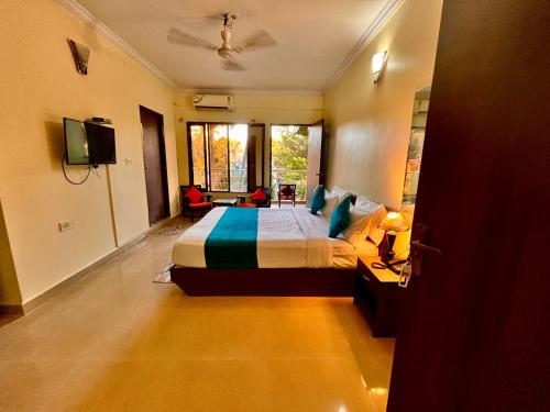 GoaHamilton Hotel & Resort Goa的一间卧室配有一张床和一台电视。