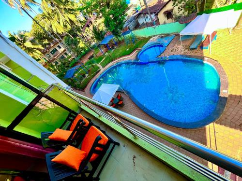 GoaHamilton Hotel & Resort Goa的享有带两把椅子的游泳池的顶部景致