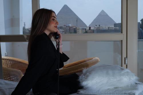 开罗The Muse Pyramids INN的坐在椅子上用麦克风说话的女人