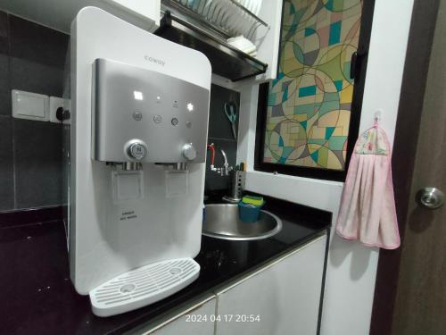 Bandar PenawarCikgukay Desaru Homestay Apartment With Pool View WiFi & Netflix的水槽旁的柜台上的白色咖啡饮水机