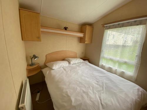 利文-法夫Caravan SK 110的一间小卧室,配有床和窗户