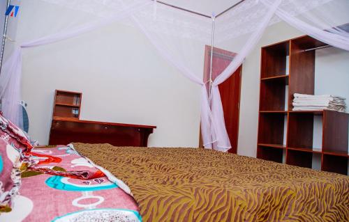 布琼布拉Sunshine Residence的一间卧室配有一张带天蓬的床