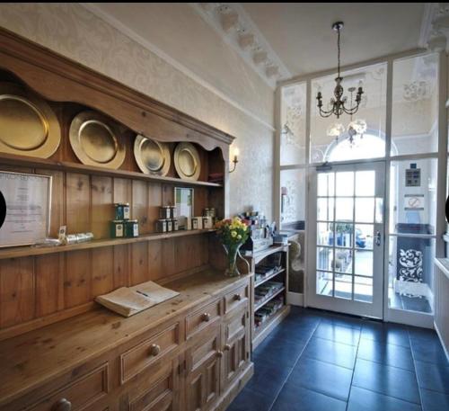 兰迪德诺Promenâd Bed & Breakfast的厨房配有木橱柜和墙上的盘子