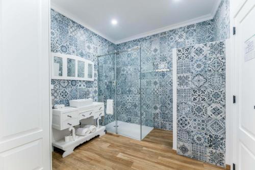 阿兰德鲁阿尔C`Alma D`Alentejo的浴室拥有蓝色和白色的墙纸,配有淋浴