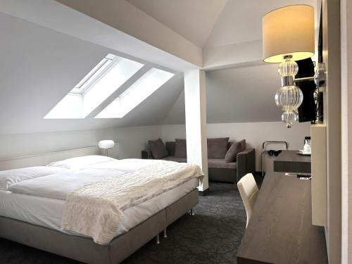 布拉格玛霍瓦酒店的一间卧室配有一张床、一张书桌和一个窗户。