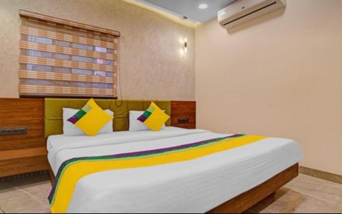 伯杰默里Hotel Abhilasha inn的卧室配有一张带彩色枕头的大型白色床。