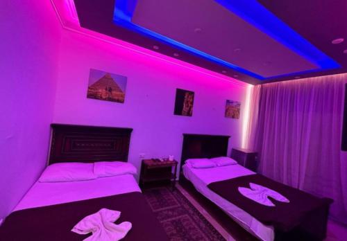 开罗Pyramids station View的紫色灯房内的两张床