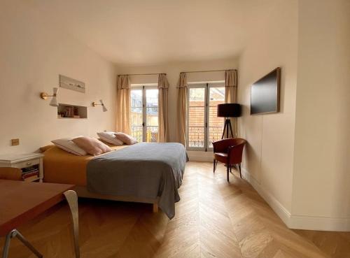 凡尔赛Grande maison hyper centre Versailles的一间卧室配有一张床、一张书桌和窗户。