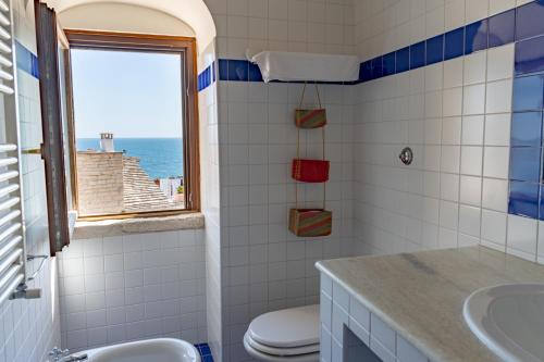焦维纳佐圣马汀酒店的一间带水槽和卫生间的浴室以及窗户。