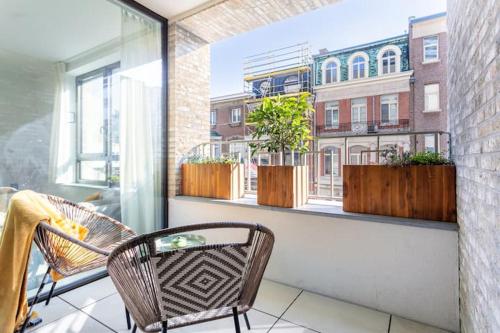 安特卫普Deluxe apartment suite with terrace的阳台配有两把椅子,窗户种有植物