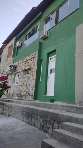 萨尔瓦多salvador/ba, casa com ar. temporada, centro的绿色建筑,设有白色的门和楼梯