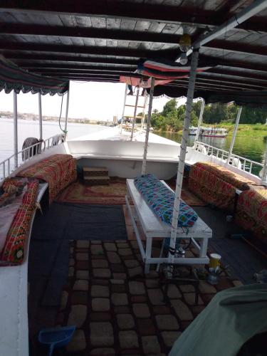阿斯旺Ozzy Tourism的船上配有一张床,甲板上设有长凳