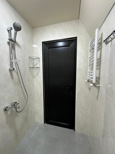 科布列季Cottage Eco house的浴室设有黑色的门,配有淋浴
