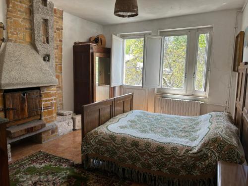 圣埃乌费米亚阿马伊埃拉tipica casa in pietra immersa nella natura..的卧室配有一张床、壁炉和窗户。