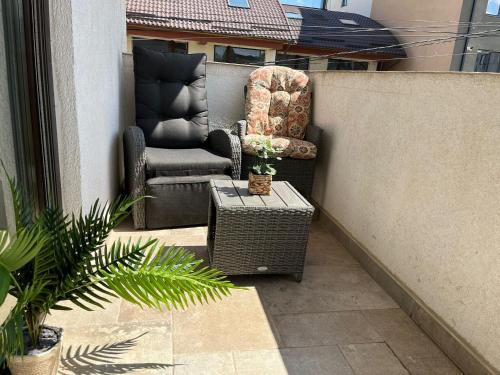 北马马亚-讷沃达里Holidays Makerel Lodge Vibes Mamaia Nord的庭院设有两把椅子、一张桌子和围栏