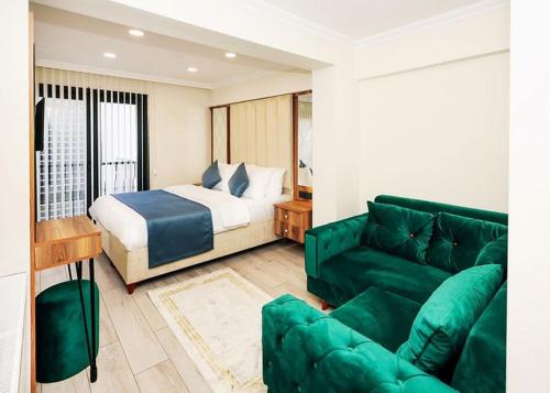 ArnavutköyGRAND VİCTORY OTEL的客厅配有床和绿色沙发