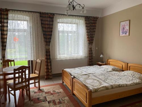 ŻarkiJurajka的卧室配有一张床和一张桌子及椅子